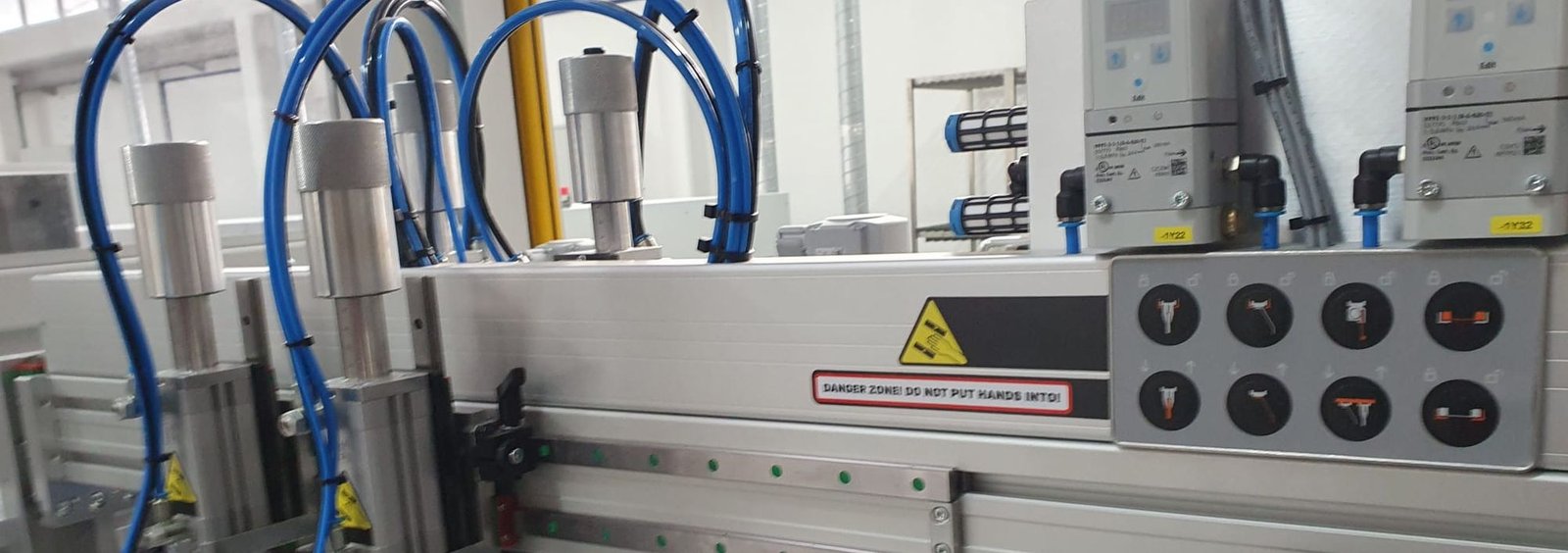 Detalle de una máquina automática con cilindros neumáticos y botones de mando